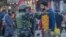 A man talks to an Indian paramilitary soldier standing guard in Srinagar, India-controlled Kashmir, Dec 23, 2023.
