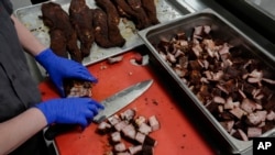 A cook prepares pork rib tips at a barbecue restaurant in Cincinnati, Ohio, June 12, 2024. Psychologists have known for years that men tend to eat more meat than women, but a study of people around the world now reveals that that's true across cultures. 
