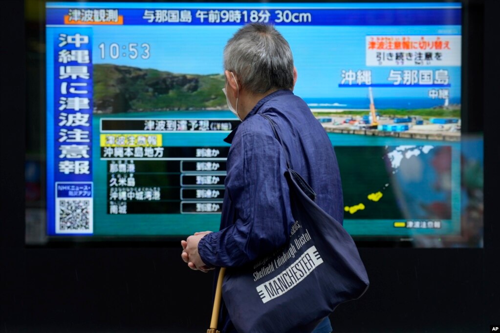 台湾强震后，东京一名男子驻足观看日本一家电视台播放对冲绳地区的海啸警报。(2024年4月3日)(photo:VOA)