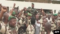 Cette capture vidéo de Gabon 24, le 30 août 2023, montre des soldats gabonais transportant le général Brice Oligui Nguema (au centre), chef de la garde présidentielle du président déchu Ali Bongo Ondimba. (Photo AFP / Gabon 24)