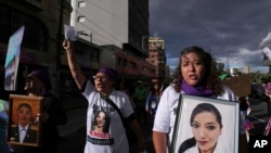 ARCHIVO - Mujeres portan retratos de víctimas de feminicidio durante una marcha para conmemorar el Día Internacional de la Mujer en Quito, Ecuador, el viernes 8 de marzo de 2024.