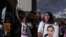 ARCHIVO - Mujeres portan retratos de víctimas de feminicidio durante una marcha para conmemorar el Día Internacional de la Mujer en Quito, Ecuador, el viernes 8 de marzo de 2024.
