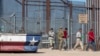 Bajo la vigilancia de un soldado del Ejército de EEUU, migrantes ingresan a El Paso, Texas, desde Ciudad Juárez, México, el 10 de mayo de 2023.
