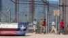 FILE - Under the watch of a U.S. Army soldier, migrants enter into El Paso, Texas, from Ciudad Juarez, Mexico, May 10, 2023.