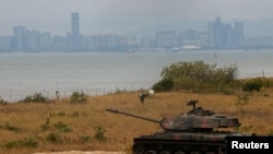 FILE - A retired military tank is seen on the beach with China in the background in Kinmen, Taiwan December 20, 2023.