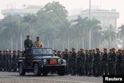 Panglima TNI Laksamana Yudo Margono dan Kapolri Listyo Sigit Prabowo menaiki mobil jeep saat memeriksa pasukan, pada upacara penempatan, menjelang KTT ASEAN ke-43 di Jakarta, 1 September 2023. (REUTERS /Willy Kurniawan)