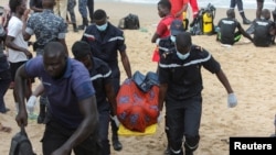 Les pompiers transportent un corps loin de la plage de Ouakam, où un bateau transportant des migrants, tentant une immigration irrégulière, s'est échoué au large de la côte, Dakar, Sénégal, le 24 juillet 2023. REUTERS/Ngouda Dione IMAGES TPX DU JOUR
