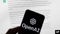 FILE - The OpenAI logo is seen on a mobile phone in front of a computer screen displaying output from ChatGPT, March 21, 2023, in Boston.