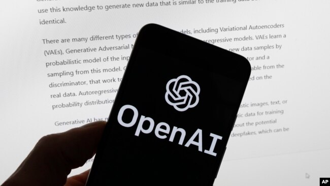 FILE - The OpenAI logo is seen on a mobile phone in front of a computer screen displaying output from ChatGPT, March 21, 2023, in Boston. (AP Photo/Michael Dwyer, File)