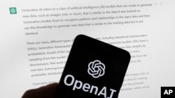 FILE - The OpenAI logo is seen on a mobile phone in front of a computer screen displaying output from ChatGPT, March 21, 2023, in Boston.