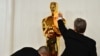 Workers polish an Oscar statue as celebrities arrive for the 96th Annual Academy Awards at the Dolby Theatre in Los Angeles, California, March 10, 2024.