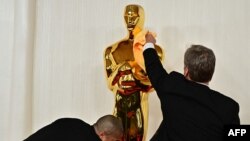 Workers polish an Oscar statue as celebrities arrive for the 96th Annual Academy Awards at the Dolby Theatre in Los Angeles, California, March 10, 2024.