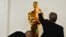 Workers polish an Oscar statue as celebrities arrive for the 96th Annual Academy Awards at the Dolby Theatre in Los Angeles, California, March 10, 2024.