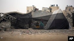 Raseljeni Palestinci zbog izraelskog bombardiranja Pojasa Gaze kuhaju u improviziranom šatorskom kampu u području Muwasi u četvrtak, 28. prosinca 2023. (AP Photo/Fatima Shbair).