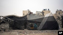 Palestinians displaced by the Israeli bombardment of the Gaza Strip cook at a makeshift tent camp in the Muwasi area, Dec. 28, 2023.