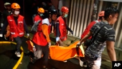 Rescuers carry the body of a victim of a fire in Jakarta, Indonesia, March 3, 2023. 