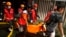 Rescuers carry the body of a victim of a fire in Jakarta, Indonesia, March 3, 2023. 
