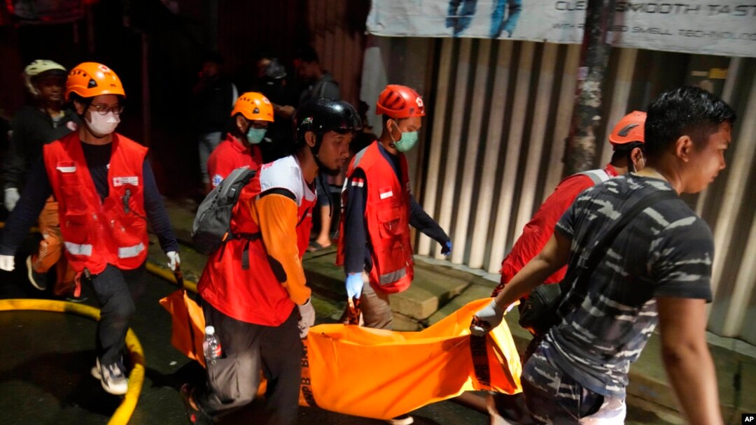 Rescuers carry the body of a victim of a fire in Jakarta, Indonesia, March 3, 2023. 