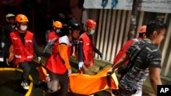 Rescuers carry the body of a victim of a fire in Jakarta, Indonesia, March 3, 2023. 