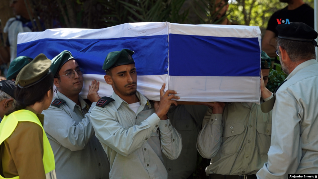 Soldados israelíes sostienen un ataúd cubierto con la bandera de Israel durante un funeral colectivo a militares caídos durante los enfrentamientos con Hamás, en Jerusalén, el 13 de octubre de 2023.