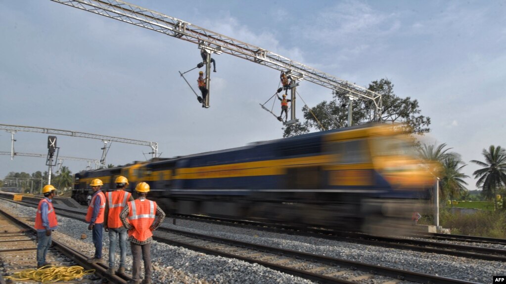 印度铁路公司的合同工在班加罗尔郊区架设用于在铁轨上牵引电缆线供机车使用的设施。（资料照片，2021年1月15 日）(photo:VOA)