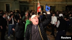 A demonstrator shouts during a protest against a draft bill on "foreign agents" in Tbilisi, Georgia, April 17, 2024. 