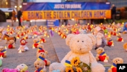 FILE - Toys sit in front of the European Commission in Brussels to highlight the reported abduction of Ukrainian children by Russia, Feb. 23, 2022. Belarus state television says its military is teaching children from occupied Ukraine about evacuating during a fire. (Avaaz via AP)