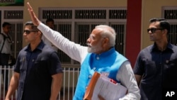 Indian Prime Minister Narendra Modi waves to the public as he returns after filing his nomination papers to contest as a candidate for the parliamentary elections in Varanasi, Uttar Pradesh state, India, May 14, 2024. 