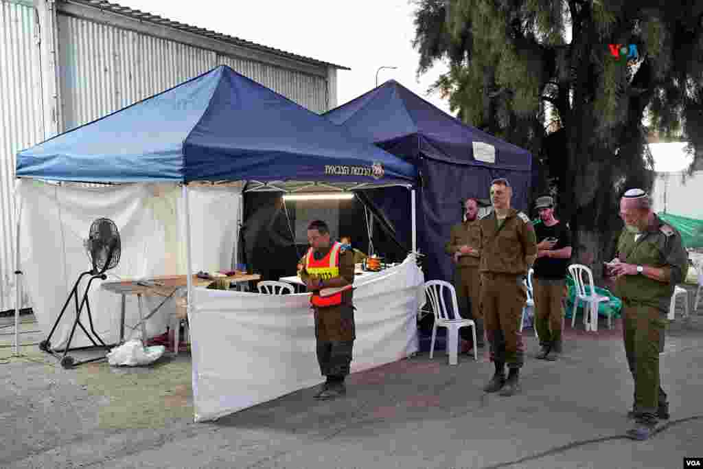 Militares israelíes rezan en la base Shura del ejército de Israel, donde se mantienen en contenedores refrigerados los restos de personas sin identificar, que fueron asesinadas por efectivos de Hamás en el ataque a Israel del pasado 7 de octubre.