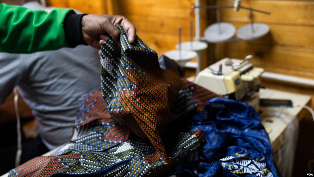 South African fashion designer Sonwabile Ndamase works on a piece of clothing at his workshop in Johannesburg. (Zaheer Cassim/VOA) 