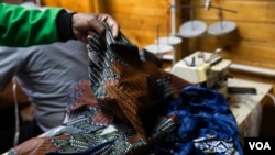 South African fashion designer Sonwabile Ndamase works on a piece of clothing at his workshop in Johannesburg. (Zaheer Cassim/VOA) 