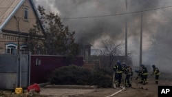 Rescue workers connect fire hoses to start extinguishing the fire after shelling by Russian forces of residential neighborhood in Kostiantynivka, Ukraine, Friday, March 10, 2023.