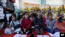 FILE - Children attend a makeshift class in Deir al Balah, Gaza Strip, April 21, 2024.