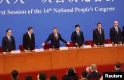中国总理李强（中）在人大会堂出席记者会。（2023年3月13日）