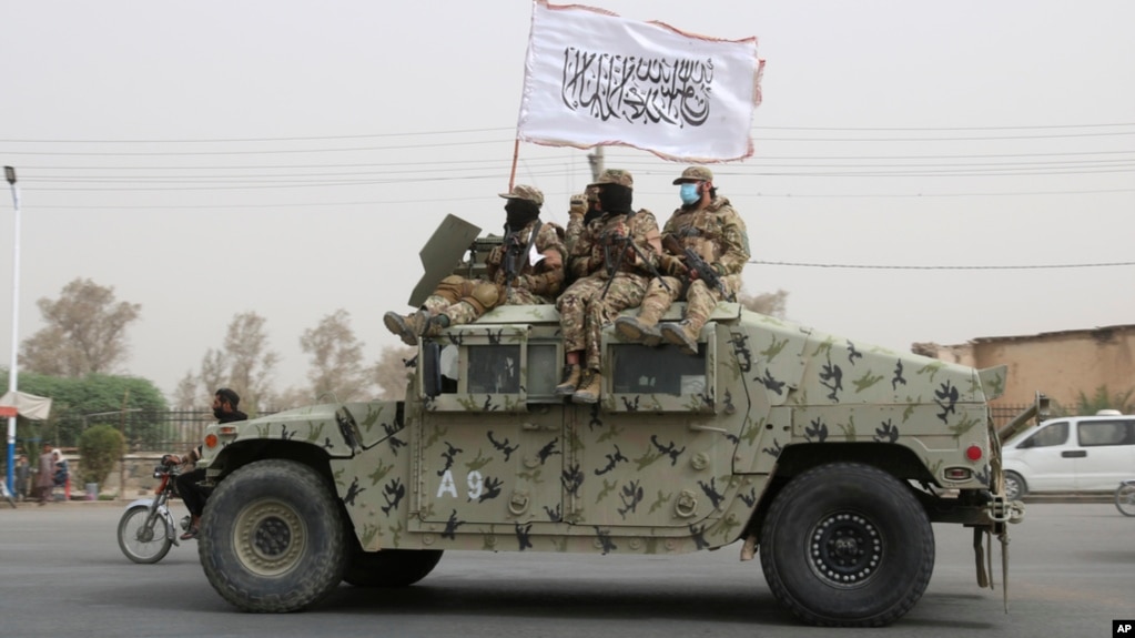 FILE - Taliban fighters patrol on the road during a celebration marking the second anniversary of the withdrawal of US-led troops from Afghanistan, in Kandahar, south of Kabul, Aug. 15, 2023. 