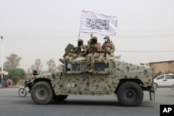 FILE - Taliban fighters patrol on the road during a celebration marking the second anniversary of the withdrawal of U.S.-led troops from Afghanistan, in Kandahar, south of Kabul, Afghanistan, Aug. 15, 2023.