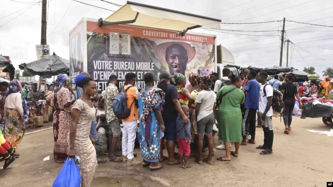 Residents line up in front of a mobile enrollment center from the Ivory Coast health authorities in Abidjan, June 10, 2024.