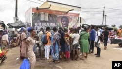 Residents line up in front of a mobile enrollment center from the Ivory Coast health authorities in Abidjan, June 10, 2024.