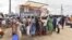 Residents line up in front of a mobile enrollment center from the Ivory Coast health authorities in Abidjan, June 10, 2024.