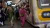 Women rush out of a train during peak hours at Churchgate station in Mumbai, India, March 20, 2023.