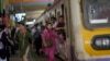 FILE - Women rush out of a train during peak hours at Churchgate station in Mumbai, India, March 20, 2023. Experts say women need to be included in larger numbers at the workplace if they and India are to reap the benefits of development.