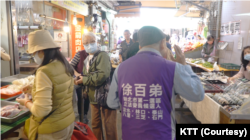 参选明年1月台湾立委选举的前香港民主党区议员徐百弟在淡水菜市场拜票 (美国之音特约记者方琦拍摄)