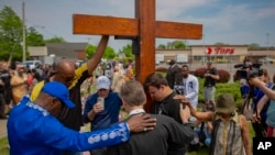 FILE - A group prays at the site of a memorial for the victims of the Buffalo supermarket shooting outside the Tops Friendly Market on Saturday, May 21, 2022, in Buffalo, N.Y. (AP Photo/Joshua Bessex, File)
