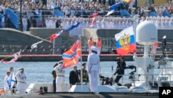 Russian President Vladimir Putin, center, reviews warships on Russian Navy Day in St. Petersburg on July 30, 2023. Russia said it began naval exercises in the Baltic Sea on Aug. 2, 2023.