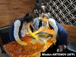 Staf menyiapkan meja untuk pelanggan di sebuah restoran Korea Utara di Beijing. (Foto: AFP/Mladen ANTONOV)