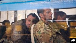 FILE - Ukrainian servicemen in a bus after they were evacuated from the besieged Mariupol's Azovstal steel plant, near a remand prison in Olyonivka, eastern Ukraine, May 17, 2022.