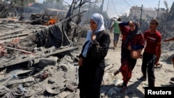 Des Palestiniens parcourent les ruines d'un camp de déplacés après une frappe israélienne à Khan Younis, dans le sud de la bande de Gaza, le 13 juillet 2024. (Reuters/Mohammed Salem)