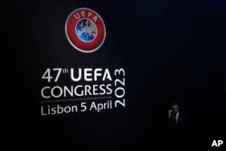 Seorang peserta kongres menelpon sambil menunggu dimulainya kongres UEFA ke-47 di Lisbon, Rabu, 5 April 2023. (AP/Armando Franca)