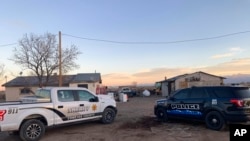 ARCHIVO - En esta fotografía publicada por la Oficina de Investigaciones de Colorado, vehículos policiales están estacionados en una de las dos propiedades donde se encontraron restos óseos a 32 kilómetros al sur-sureste de Alamosa, Colorado, el 18 de noviembre de 2020.