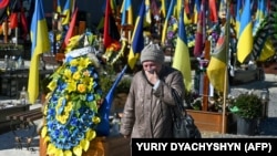 A visitor walks through Lychakiv military cemetery in Lviv, Ukraine, on March 18, 2023, during the Russian invasion of Ukraine.
